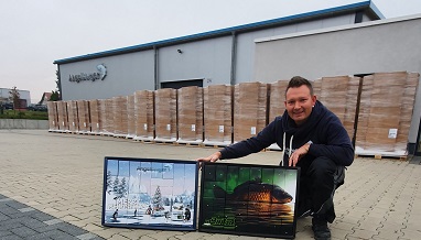 Inhaber Marcel Berger hockt vor der erweiterten Produktionsstätte von Angelsport Berger