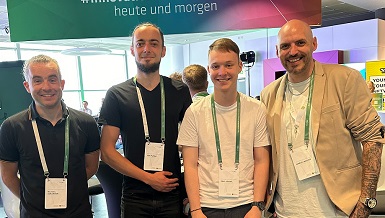 Vier Personen der TOSA home appliances GmbH stehen auf einer Messefläche und lächeln in die Kamera